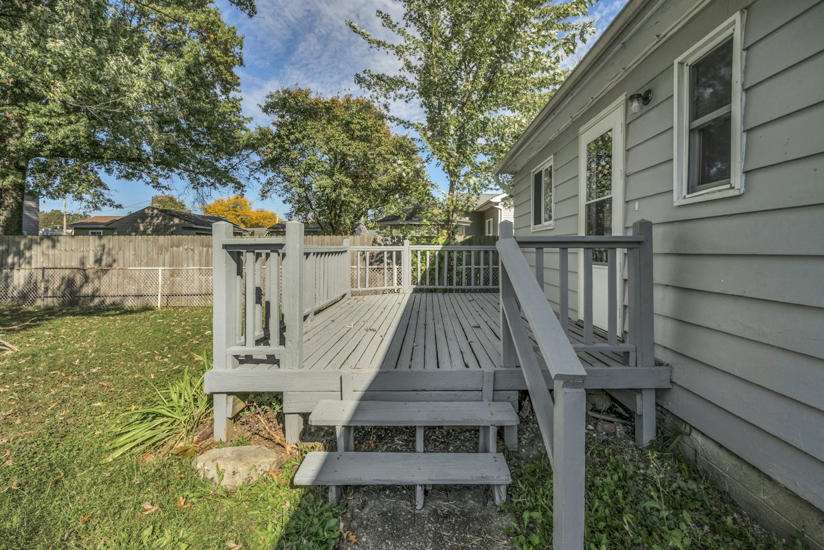 Wooden deck with stairs attached to the back of a house