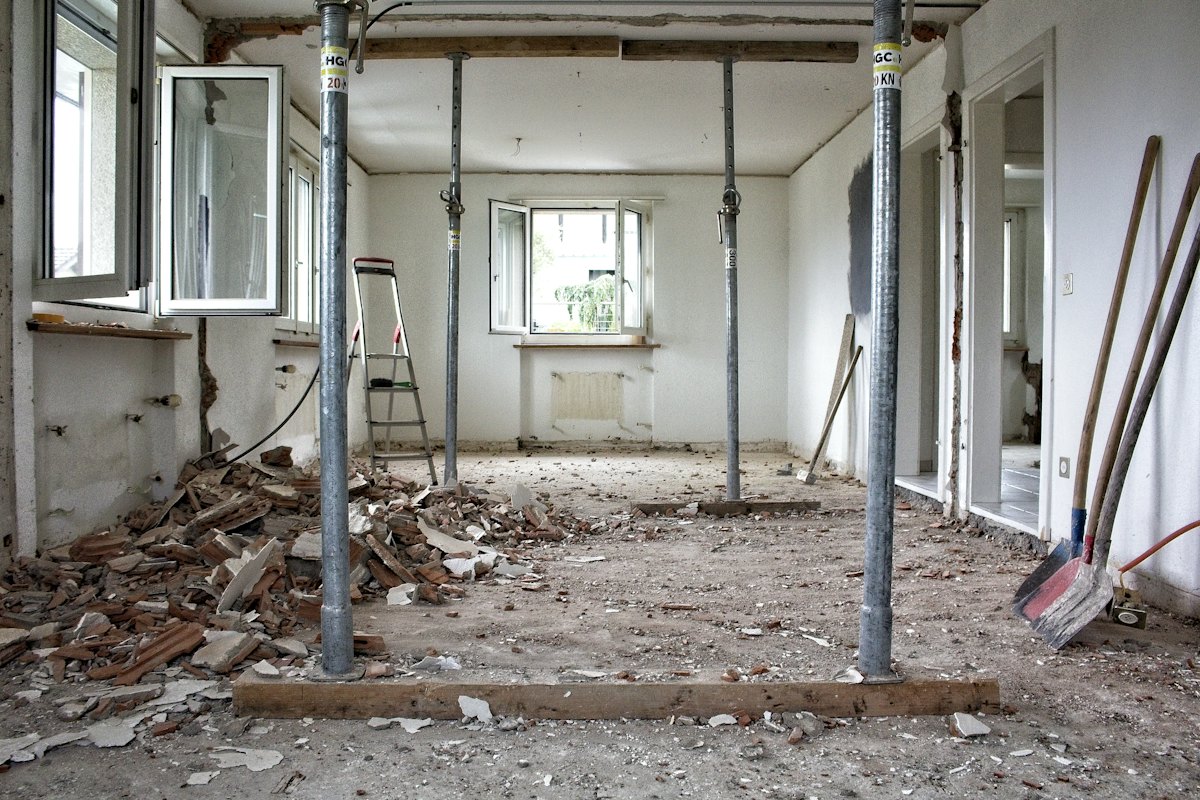 Gutted interior room with debris and temporary support posts